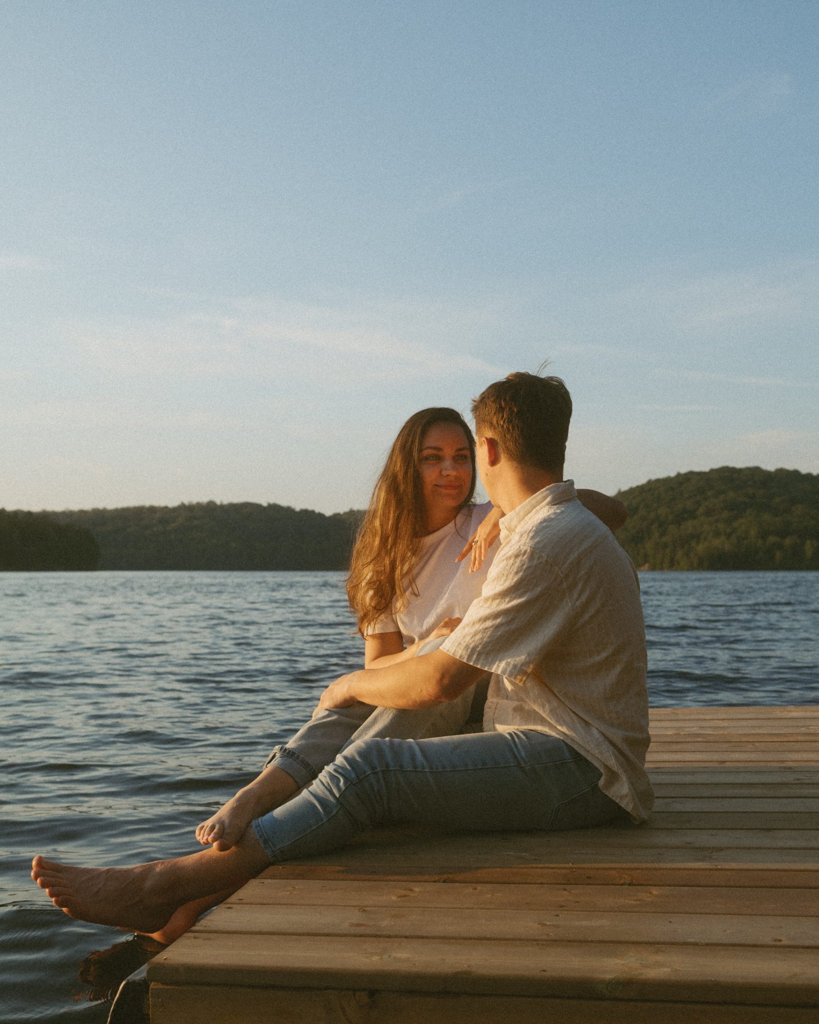 A couple kissing against an open blue sky, his arm raised