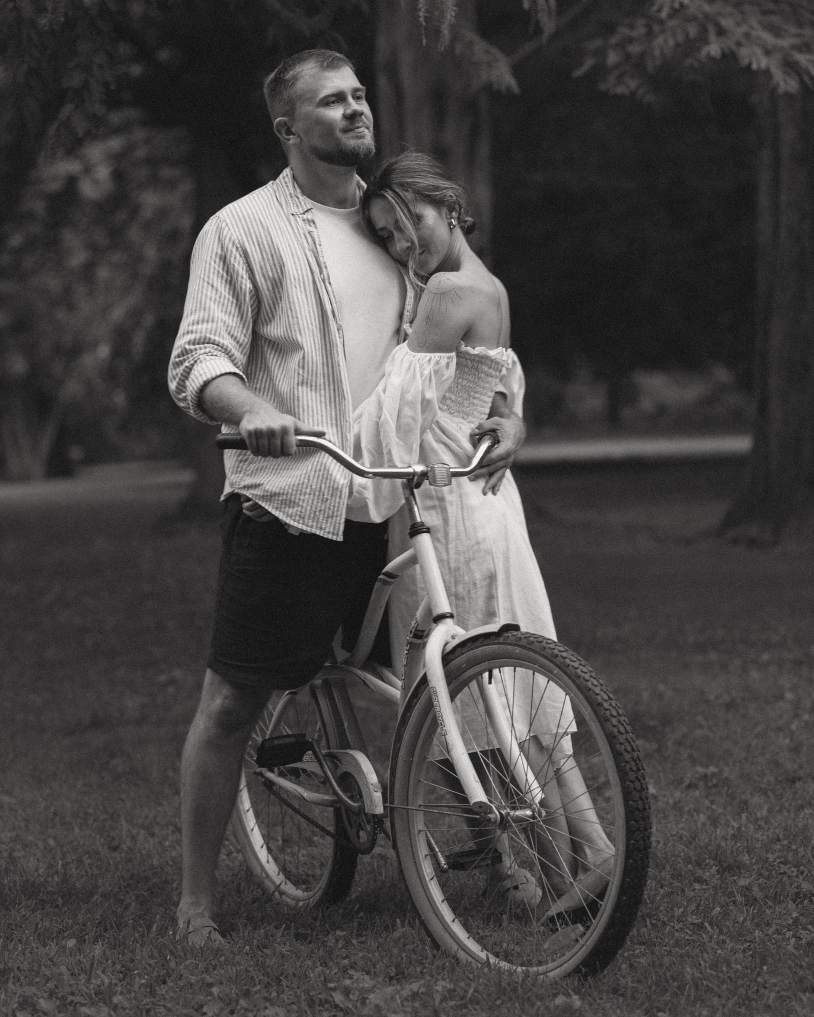 A couple face to face over the bicycle, about to laugh