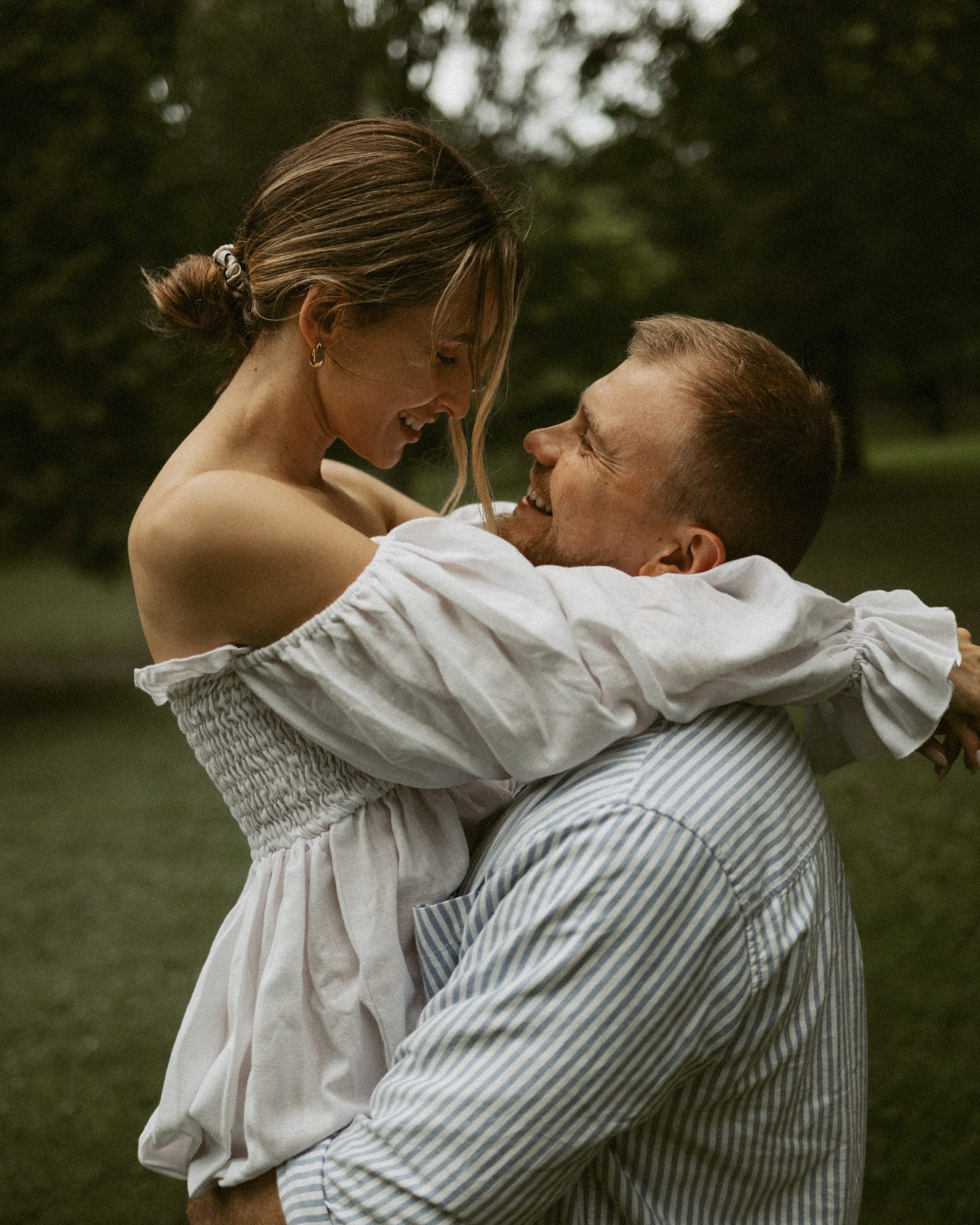 A couple close together, her face tucked against his neck