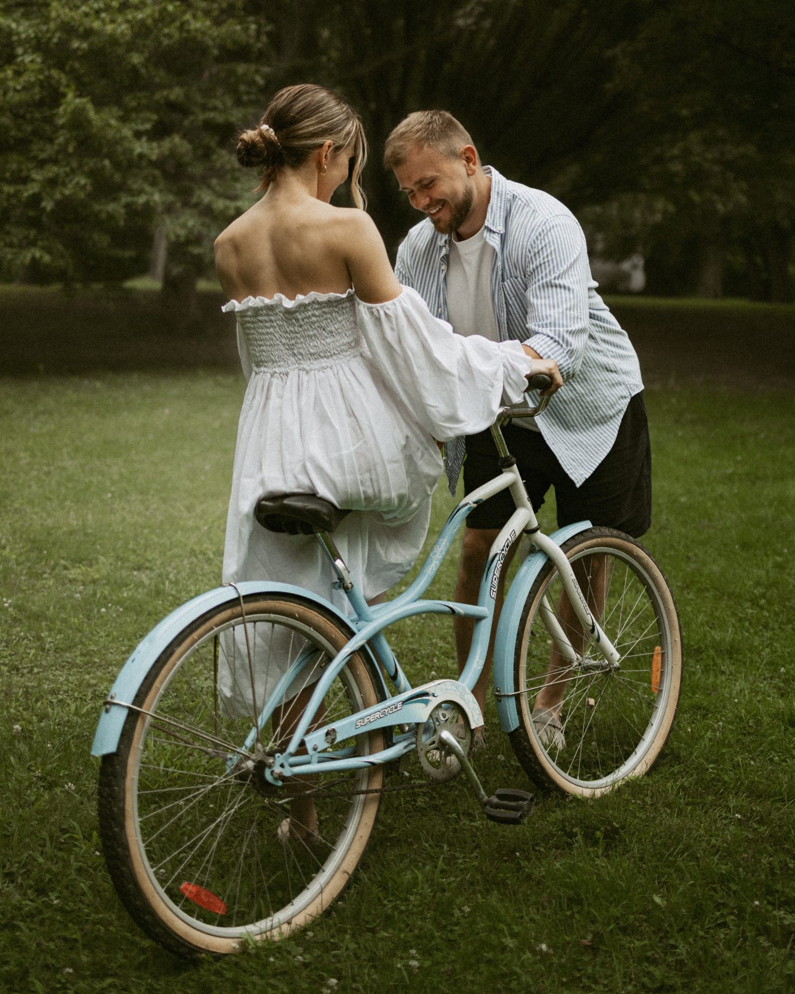 A close frame of a couple about to kiss beside their bicycle
