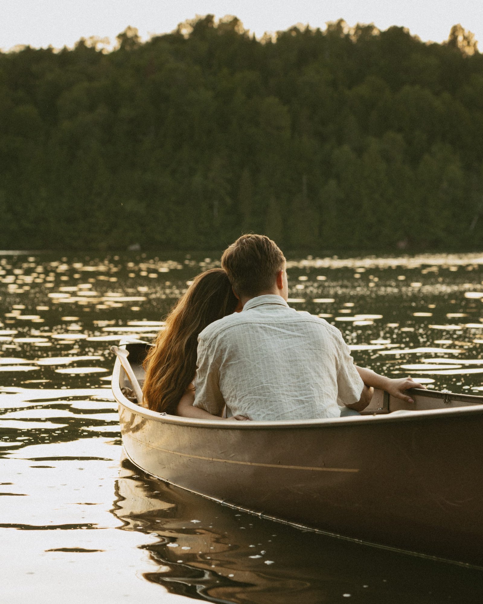 A canoe on still water carrying a couple sitting close together